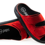 Czerwone kapcie z czarnym wnętrzem i logo s na wkładce, z dwoma szerokimi rzepami na górze.