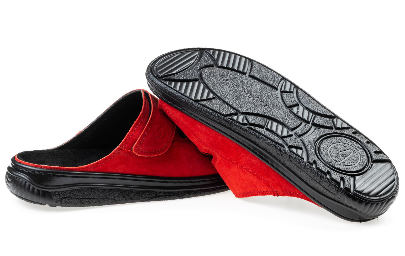 Czerwone kapcie z czarną podeszwą, jedna kapcie leży na drugiej, na białym tle.
