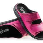 Różowe kapcie z czarnym wkładką i dwoma szerokimi rzepami, na podeszwie z teksturowanym wzorem, z logo paps.