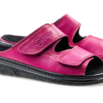 Różowe kapcie na czarnej podeszwie z dwoma regulowanymi paskami na rzepy.