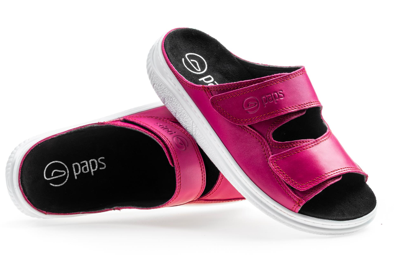 Różowe kapcie z czarnym wnętrzem i białą podeszwą, z dwoma szerokimi rzepami na wierzchu.