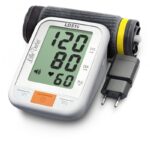 Elektroniczny ciśnieniomierz z wyświetlaczem pokazującym 120/80 mm Hg, puls 60, i funkcją dźwiękową.